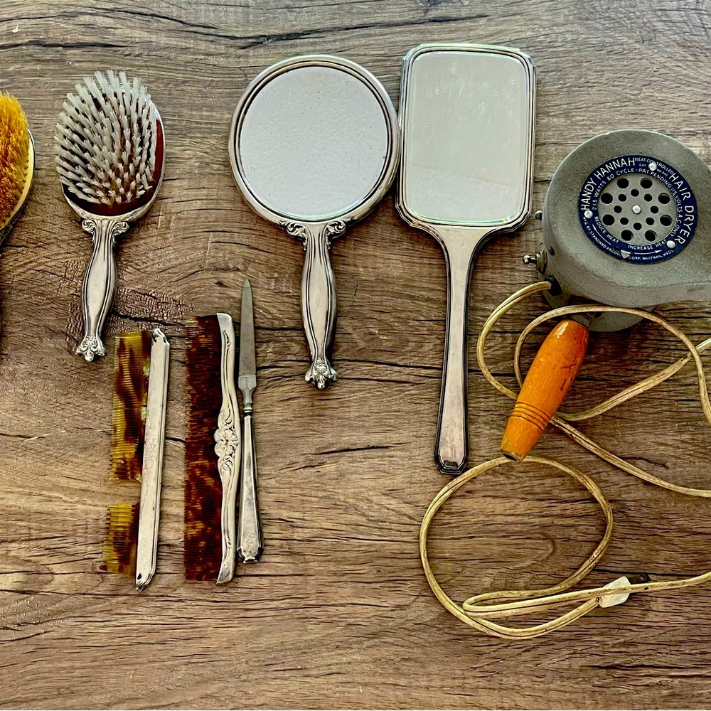 Vintage hair brushes, combs, mirrors, and hairdryer.